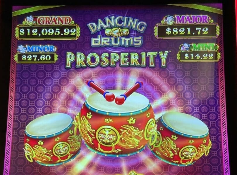Dancing Drums Prosperity by Scientific Games logo and progressives